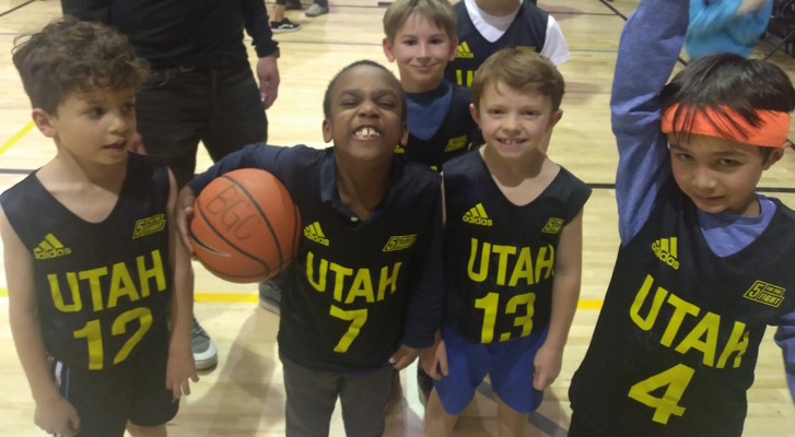 Five boys in Utah Jazz jerseys with a basketball