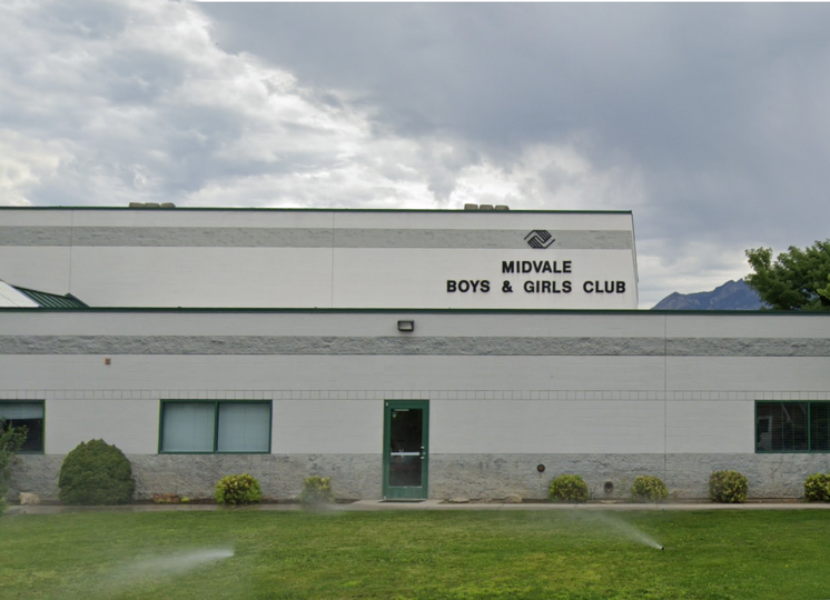 A large white building with two gray stripes at the top and the name Midvale Boys & Girls Club