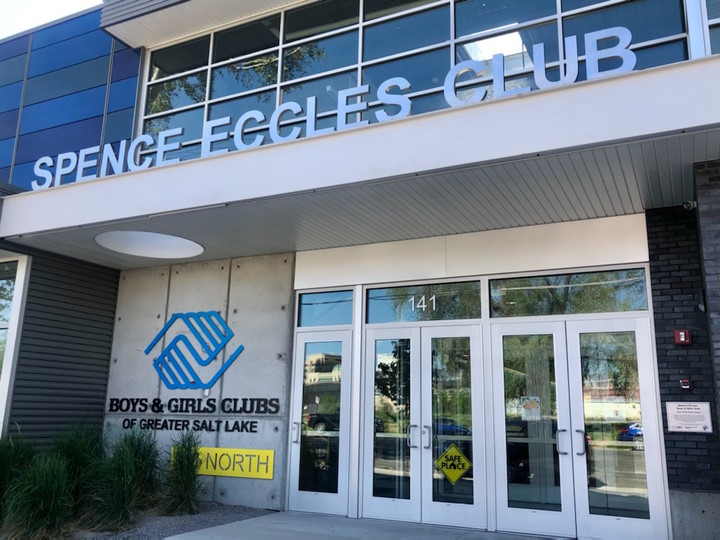 Two sets of glass doors at the entrance of the building, with a Boys & Girls Club logo on a wall to the left